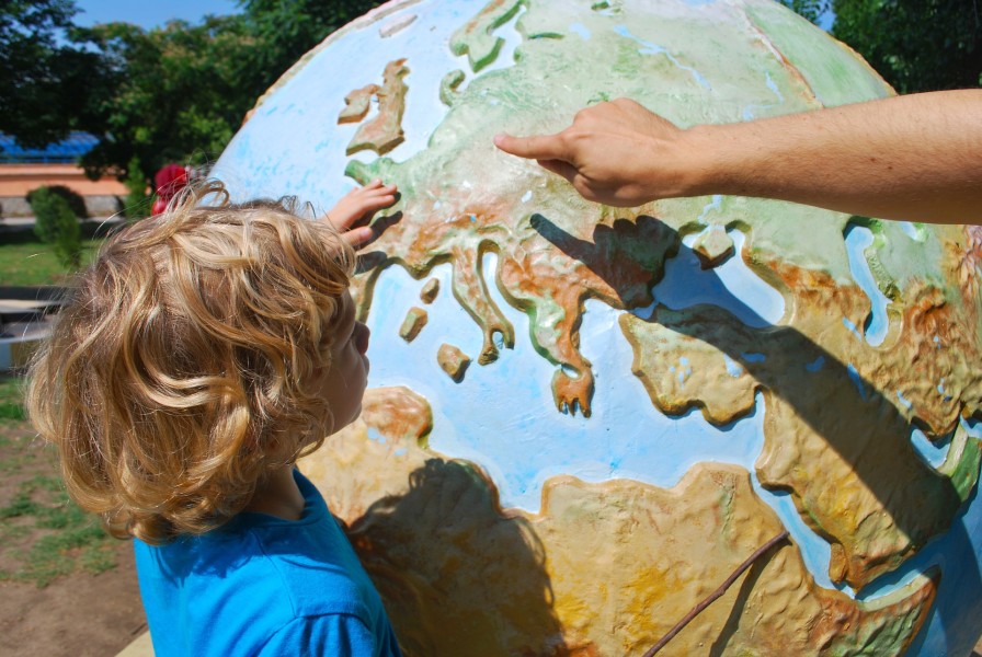 Image of Child with large globe outdoors