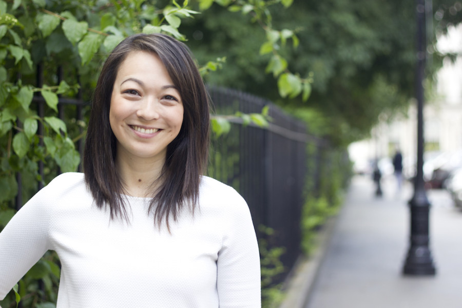 Image of A smiling woman standing on a leafy street
