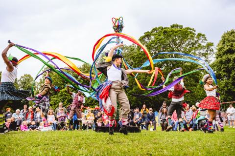 A group of people watching an outdoor dance performance