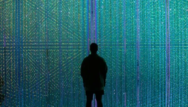 silhouette of a person in front of a wall of blue and green lights