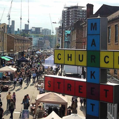 A bustling London market with a sign saying "Church Street Market"