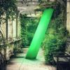 An established garden walkway with a big green glowing 3D forward slash in it